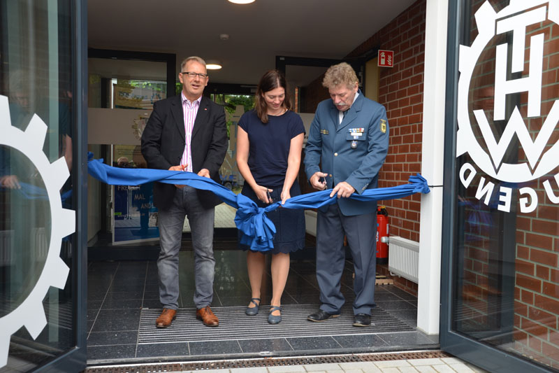 Mit Johannes Kahrs und Kristin Nestner von der BImA durchschnitt der Ortsbeauftragte anschließend eine Schleife am Eingang des Neubaus als symbolische Öffnung des Gebäudes.